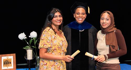 Phi Theta Kappa induction ceremony two students standing with scrolls with Dr Willis standing between them