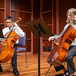 The Music Institute two young musicians playing cellos on stage