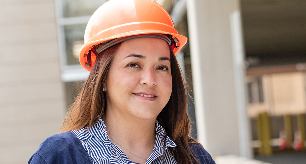 Student at a construction site wearing an orange hard hat, illustrating the Construction Management apprenticeship