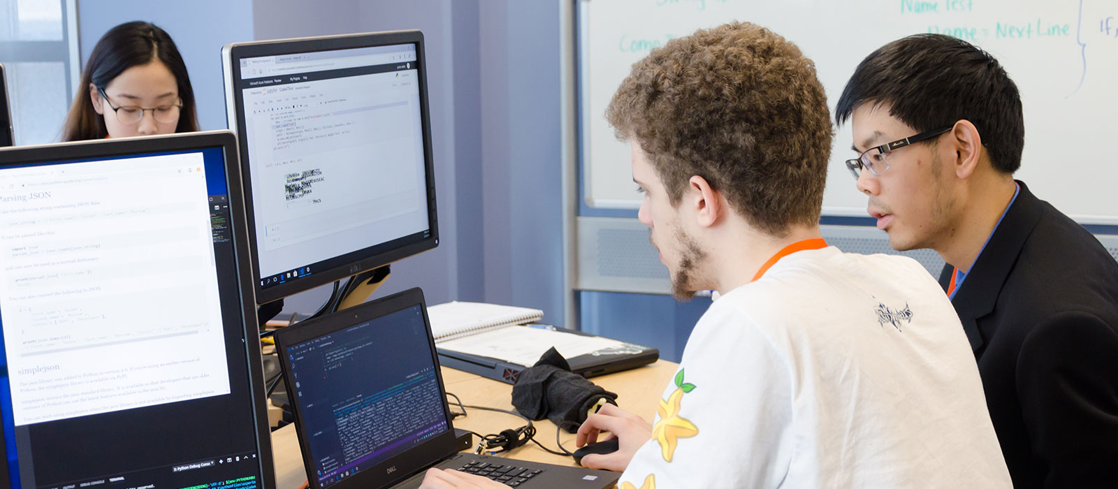 Students sitting in front of a computer