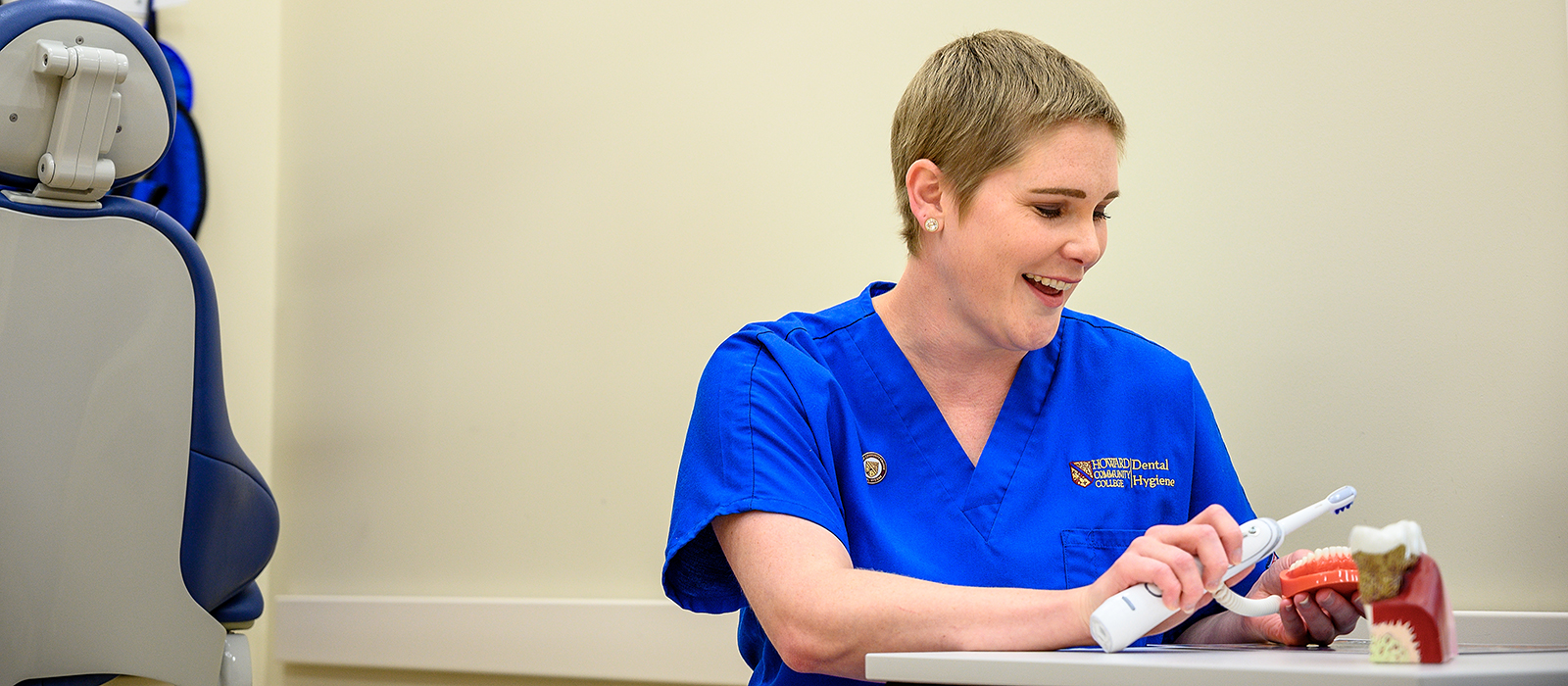 Person in scrubs using dental equipment