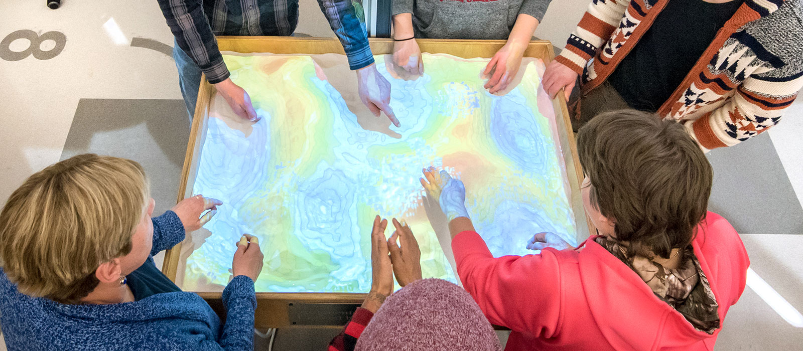 Students working around an image of a topographical map