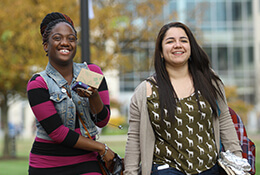 Two students walking together on a college campus. Discover why HCC is right for you.