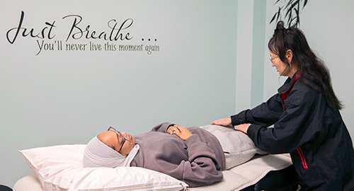 A student receiving Reiki treatment by a practitioner in a Wellness Room.